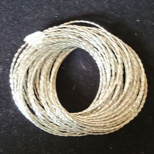 Statement bracelet. 44 bright silver tone interlocked bangles